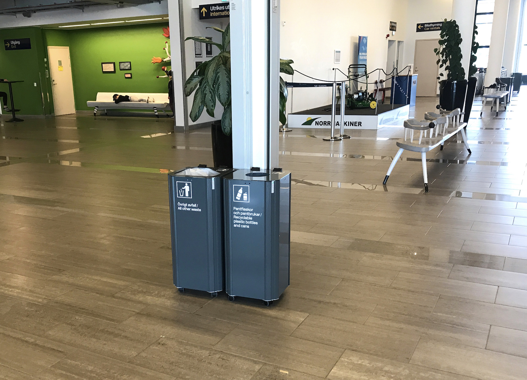 Två gråblå Sortify källsorteringskärl i ankomsthallen på Umeå Airport